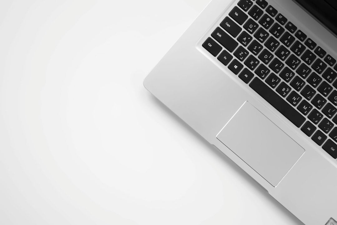 Silver laptop keyboard and trackpad viewed from above on a white desk