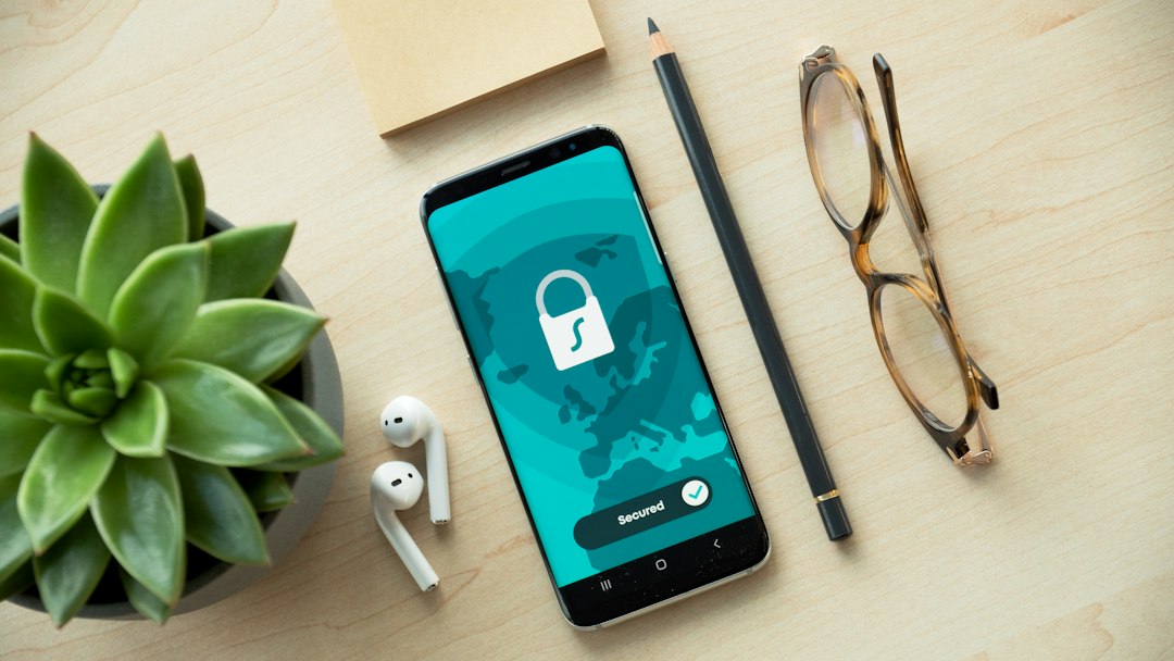 A smartphone displaying a security lock icon on a wooden desk, representing IMEI and device security verification