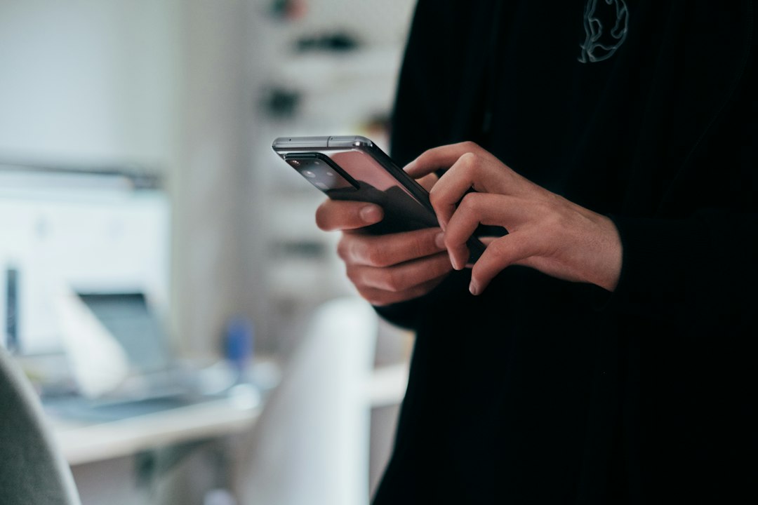 Person holding a smartphone, illustrating the global phone shortage driven by rising RAM and NAND memory prices