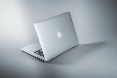 Silver MacBook laptop on a white table, representing Apple touchscreen MacBook Pro redesign