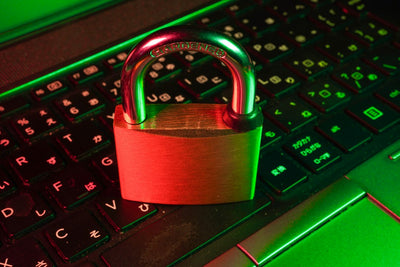Red padlock resting on a laptop keyboard, symbolizing data privacy and security concerns around Windows features