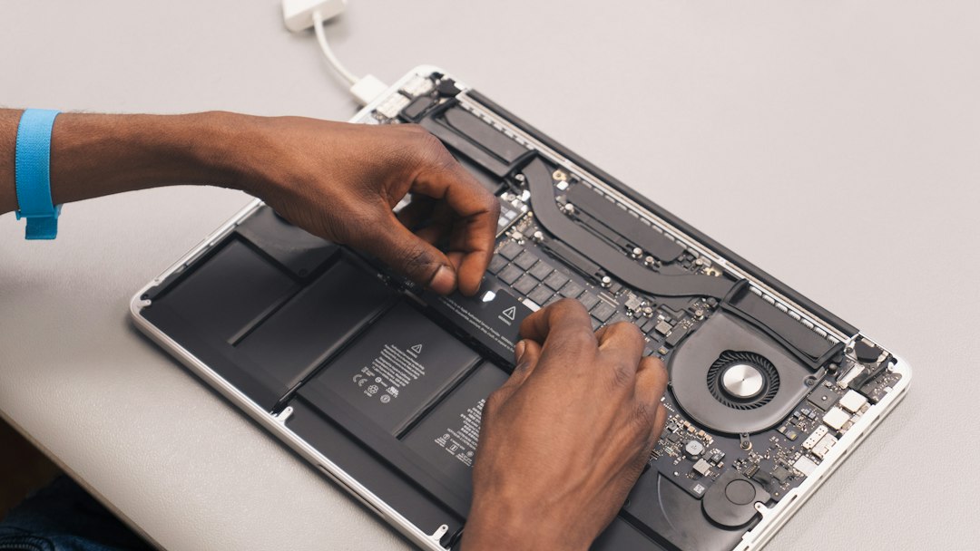 Technician inspecting a refurbished laptop before grading it Good or Fair