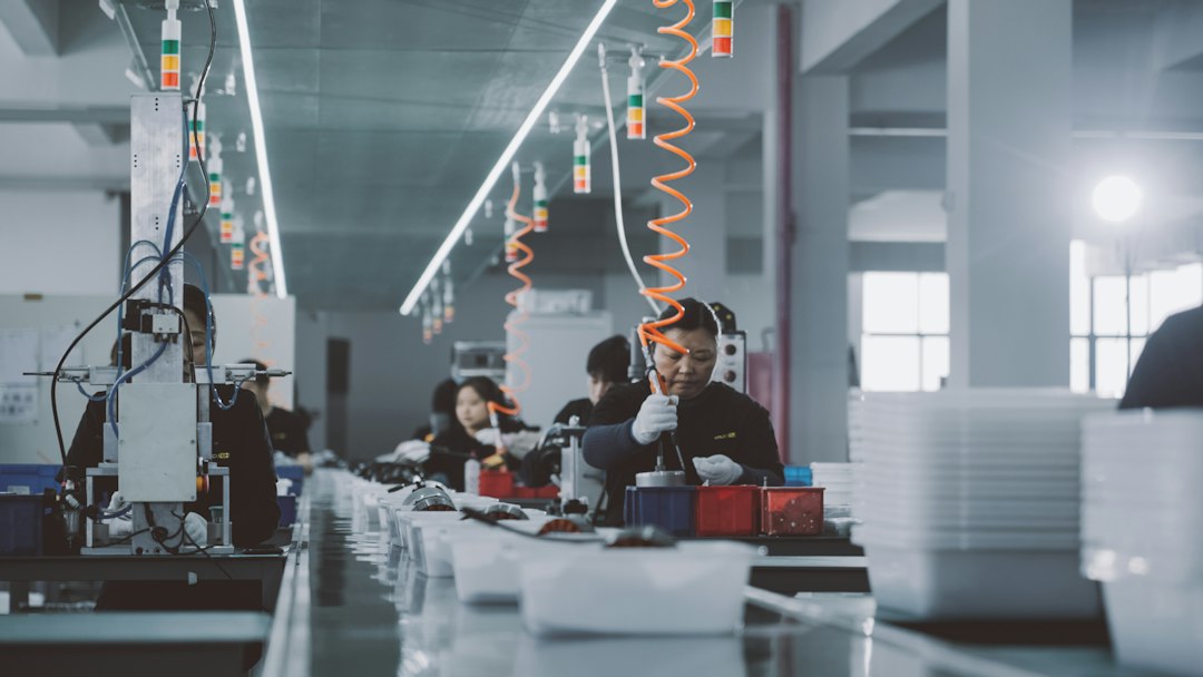 Factory workers on an electronics assembly line, representing the kind of manufacturing floor MSI is setting up in Chennai